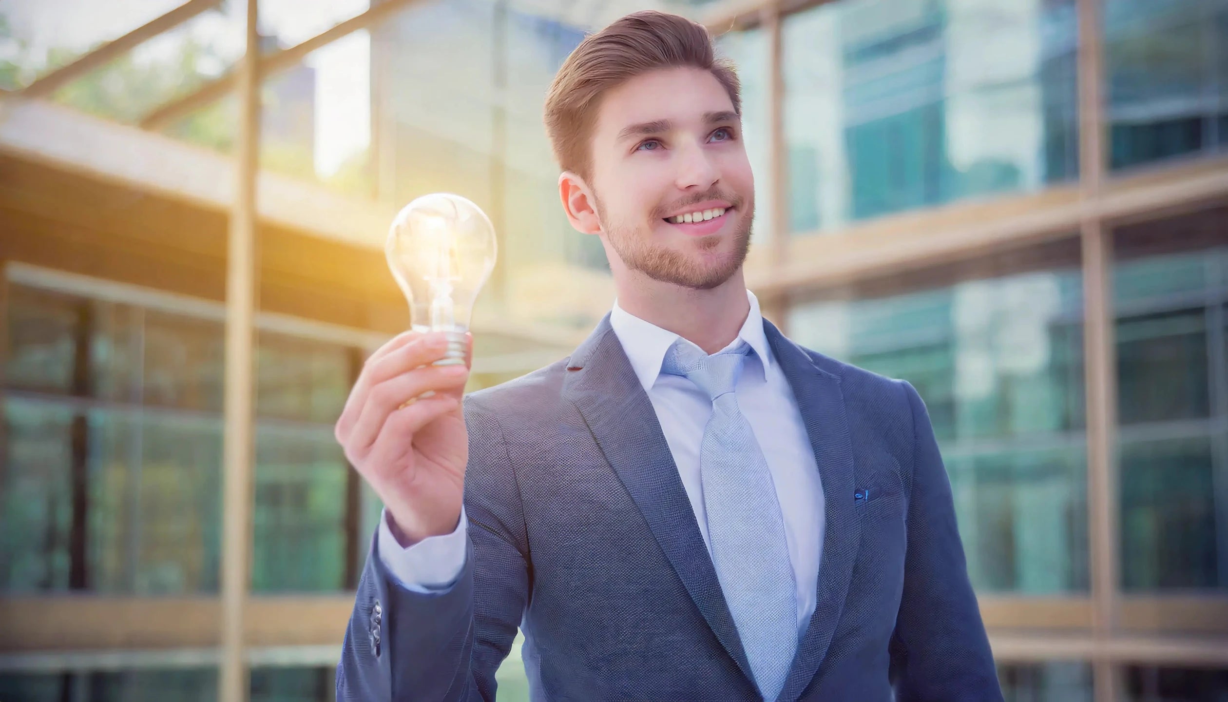 signore d'affari che tiene in mano una lampadina illuminata, per illuminare le soluzioni che trova